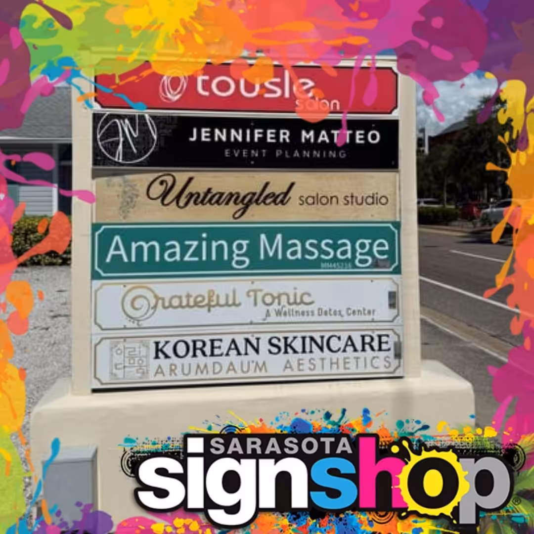 A colorful image displays a business signpost with six businesses listed, showcasing storefront signs Sarasota. The Sarasota Sign Shop logo appears at the bottom with a vibrant paint splash border.