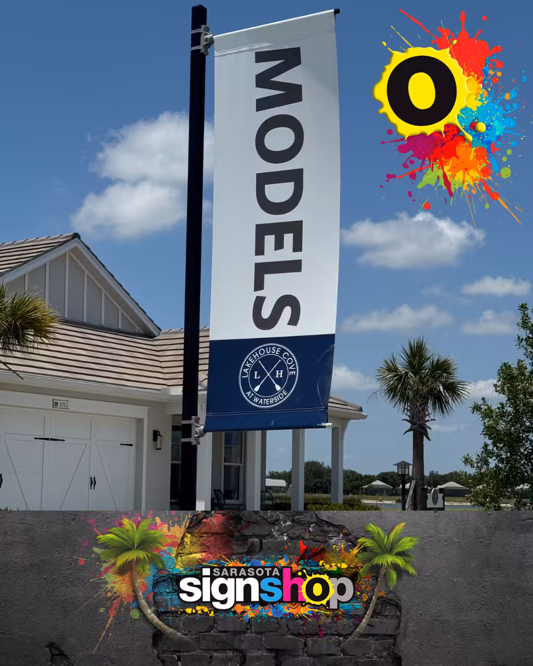 A vertical MODELS banner stands outside a white house, perfect for new community signage. Colorful paint splatters and the Sarasota Sign Shop logo decorate the image with palm trees and blue sky in the background.