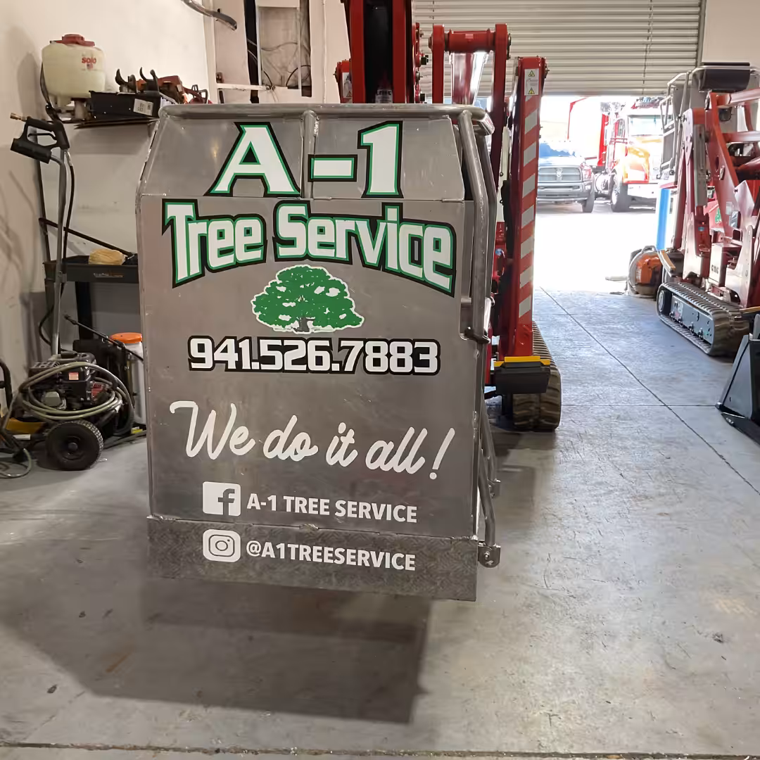 A metal vehicle bin in a garage displays A-1 Tree Service, a Home Service phone number, social media handles, and We do it all! Graphics include a green tree and social media icons for Facebook and Instagram.